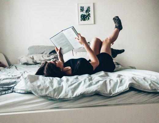 image of a woman reading a book on a bed